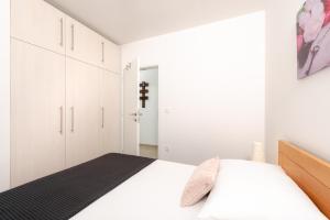 a white bedroom with a bed and white cabinets at Azalea Apartments in Podstrana +32 photos