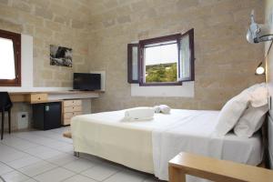Un dormitorio con una cama con un teléfono. en Hotel Delle Cave en Favignana