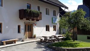 a group of picnic tables in front of a building at Apartments & Hostel Bohinj in Bohinj