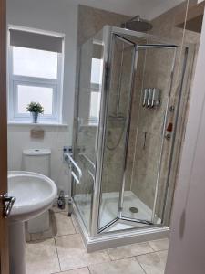 uma casa de banho com um chuveiro, um WC e um lavatório. em Woodlands Court Holiday Retreat em Paulton