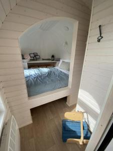 East LooeにあるThe Pilchard - Lydcott Glamping Cornwall, sea viewのベッドルーム(ベッド1台、大きな鏡付)