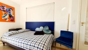 um quarto com uma cama e uma cadeira azul em River View & Close to the Beach - Quarto em Almada em Almada