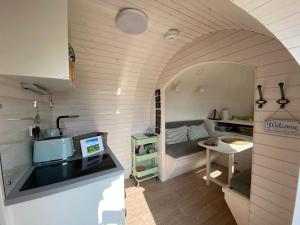 a small kitchen in a tiny house with a table at The Pilchard - Lydcott Glamping Cornwall, sea view in East Looe