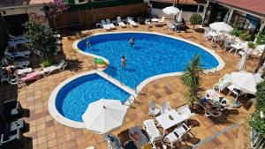 an overhead view of a swimming pool with chairs and umbrellas at Hotel Mireia in Lloret de Mar
