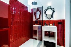 a red tiled bathroom with red tiles and mirrors at Casa Dei Viaggiatori - The House Of Travelers in Como