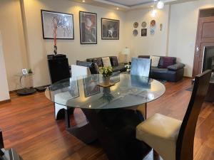 sala de estar con mesa de cristal y sofá en Departamento Premium, categoría 5 estrellas, en Cochabamba