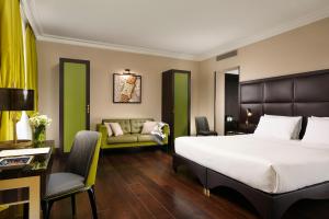 Hotel L'Orologio Roma - WTB Hotels في روما: غرفه فندقيه بسرير واريكه