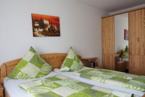 a bedroom with a bed with green and white pillows at Gasthaus Zur Linde in Kleinvach