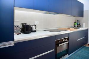 eine Küche mit blauen Schränken und einem Waschbecken in der Unterkunft Blue Bellagio by Wonderful Italy in Bellagio