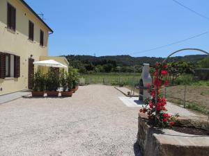 een oprit naar een huis met bloemen en een paraplu bij Casa Emy - Argonauti Vacanze in Portoferraio