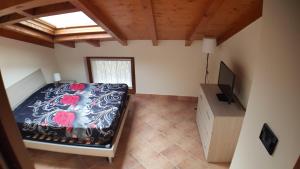 a bedroom with a bed and a flat screen tv at CASA VAL DEL RISO in Gorno