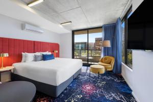 pokój hotelowy z łóżkiem i dużym oknem w obiekcie Mercure Melbourne St Kilda Road w Melbourne