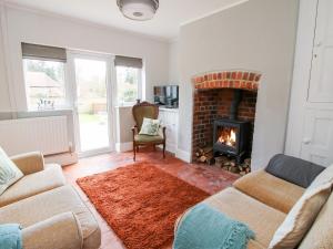 a living room with a fireplace and a couch at The Ferns in Ludlow