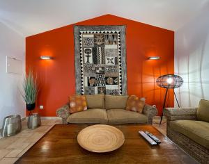 ザンブジェイラ・ド・マールにあるHerdade do Kuanzaのリビングルーム(オレンジ色の壁、ソファ付)