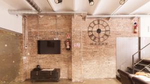 a brick wall with a tv on it at ApartsNouBcn Industria-Gracia in Barcelona