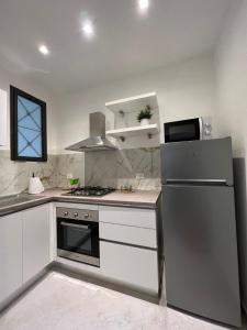 a kitchen with white cabinets and a stainless steel refrigerator at Al Vicolo in Terracina