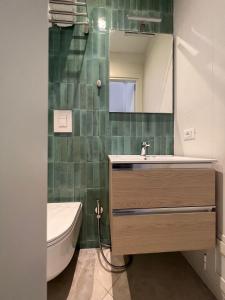 bagno con lavandino, specchio e servizi igienici di Al Vicolo a Terracina