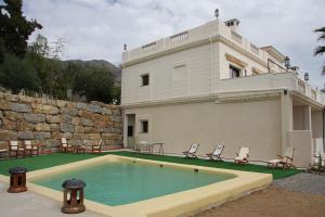 a house with a swimming pool in front of it at Hotel Villarocamar in Mijas