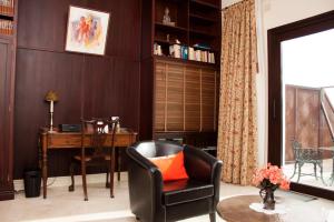 a living room with a desk and a chair with an orange pillow at Hotel Villarocamar in Mijas