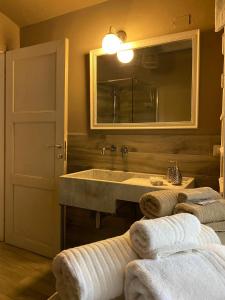 a bathroom with a sink and a mirror and towels at La Culla di Bacco in Castagnole Monferrato