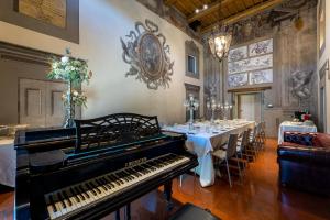 um piano numa sala com uma longa mesa com mesas em Nello's, Villa di pregio con SPA em Cortona