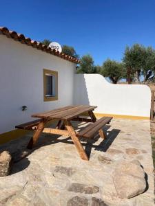 einem Picknicktisch aus Holz vor einem Gebäude in der Unterkunft Kochab Crato Alentejo in Crato