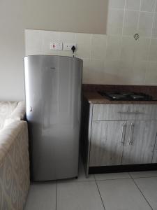 een keuken met een roestvrijstalen koelkast en een aanrecht bij 2 bedroomed apartment with en-suite and kitchenette - 2064 in Harare