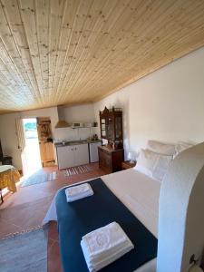 a bedroom with a large bed with a wooden ceiling at Kochab Crato Alentejo in Crato