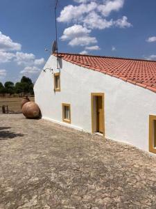 a white building with a red roof and a largearton at Kochab Crato Alentejo in Crato
