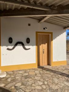 a wall with a mustache on the side of a building at Kochab Crato Alentejo in Crato