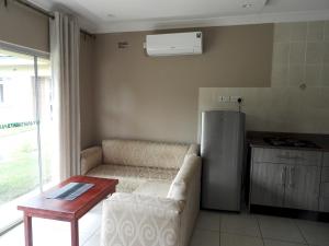 a living room with a couch and a refrigerator at Executive apartment with 2 beds kitchenette - 2072 in Harare