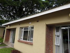 a house with a window and a brick at Executive apartment with 2 beds kitchenette - 2072 in Harare