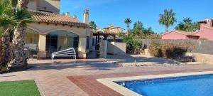 a house with a swimming pool in front of a house at HL 002 Holiday rentals 4 Bedrooms 4 Bathroom villa with private pool in Fuente Alamo