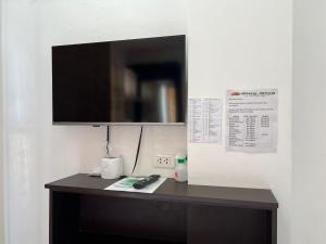 a black desk with a television on a wall at GingGing Hotel And Resort in Oslob