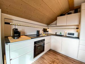 a kitchen with white cabinets and a stove top oven at Bergfried in Oberstaufen