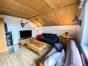 a living room with a couch and a tv at Bergfried in Oberstaufen