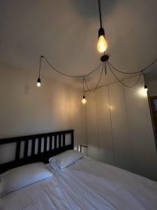 Un dormitorio con una cama blanca con luces. en Apartament na Rydlówce, en Cracovia