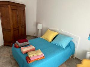 a bedroom with a blue bed with towels on it at Villa de 4 chambres avec piscine privee jardin clos et wifi a Borgo in Borgo