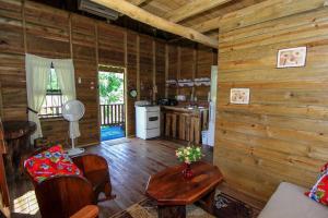 een woonkamer van een blokhut met houten wanden bij Pilgrims Paradise Cabin 2 in San Ignacio