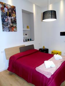 1 dormitorio con 1 cama grande con manta roja en Massimo Luxury Rooms en Palermo
