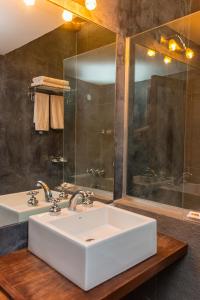 La salle de bains est pourvue d'un lavabo blanc et d'une douche. dans l'établissement Alas del Alma, à Tilcara