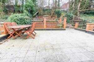 a patio with a table and chairs and a fence at Beautiful 3 bedroom house, Ashbnhm,Luton free parking in Luton
