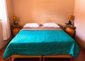 a bed in a room with two nightstands and two lamps at Alas del Alma in Tilcara