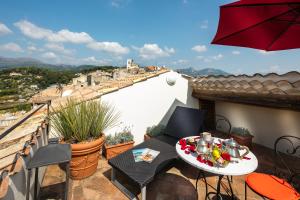 a balcony with a table with food and an umbrella at Hotel Le Saint Paul in Saint Paul de Vence