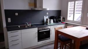 a kitchen with a sink and a stove and a table at Altstadt-Domizil 7 in Leer