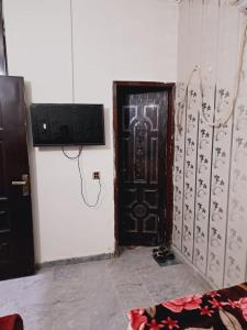 Cette chambre est dotée d'une porte noire et d'un mur avec dans l'établissement Lords Hotel, à Lahore