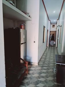 a hallway with a refrigerator in a room with a tile floor at Lords Hotel in Lahore