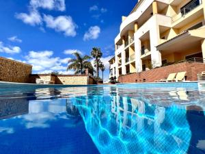 a swimming pool in front of a building at Albufeira Experience With Pool by Homing in Albufeira