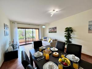 a living room with a table and chairs and a couch at Albufeira Experience With Pool by Homing in Albufeira