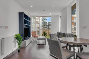 a living room with a table and chairs and a tv at Modern 01 & 02 Bed Apartment in Canary Wharf in London